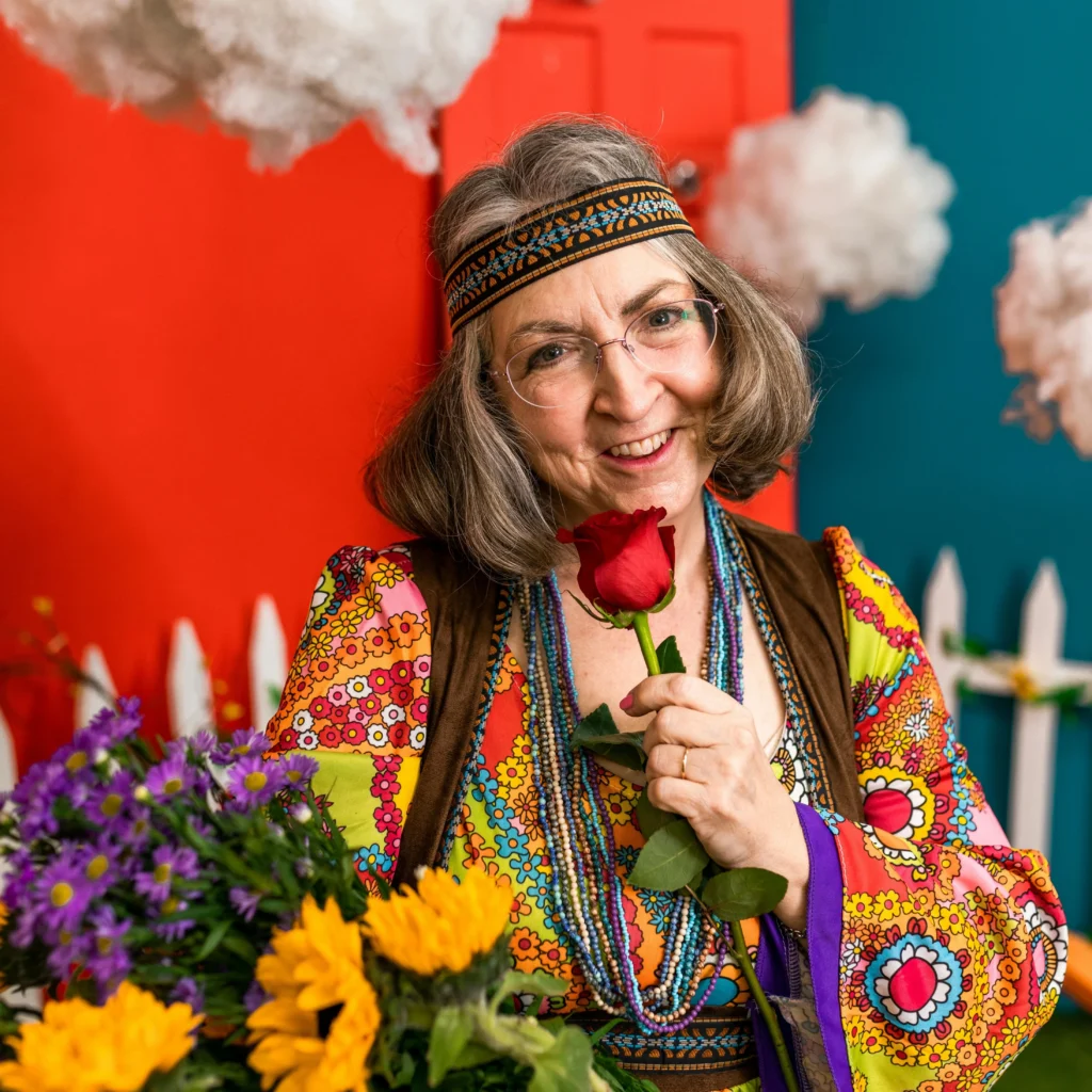 Biographe familiale : raconter les 70's, femme hippie avec des fleurs dans les bras