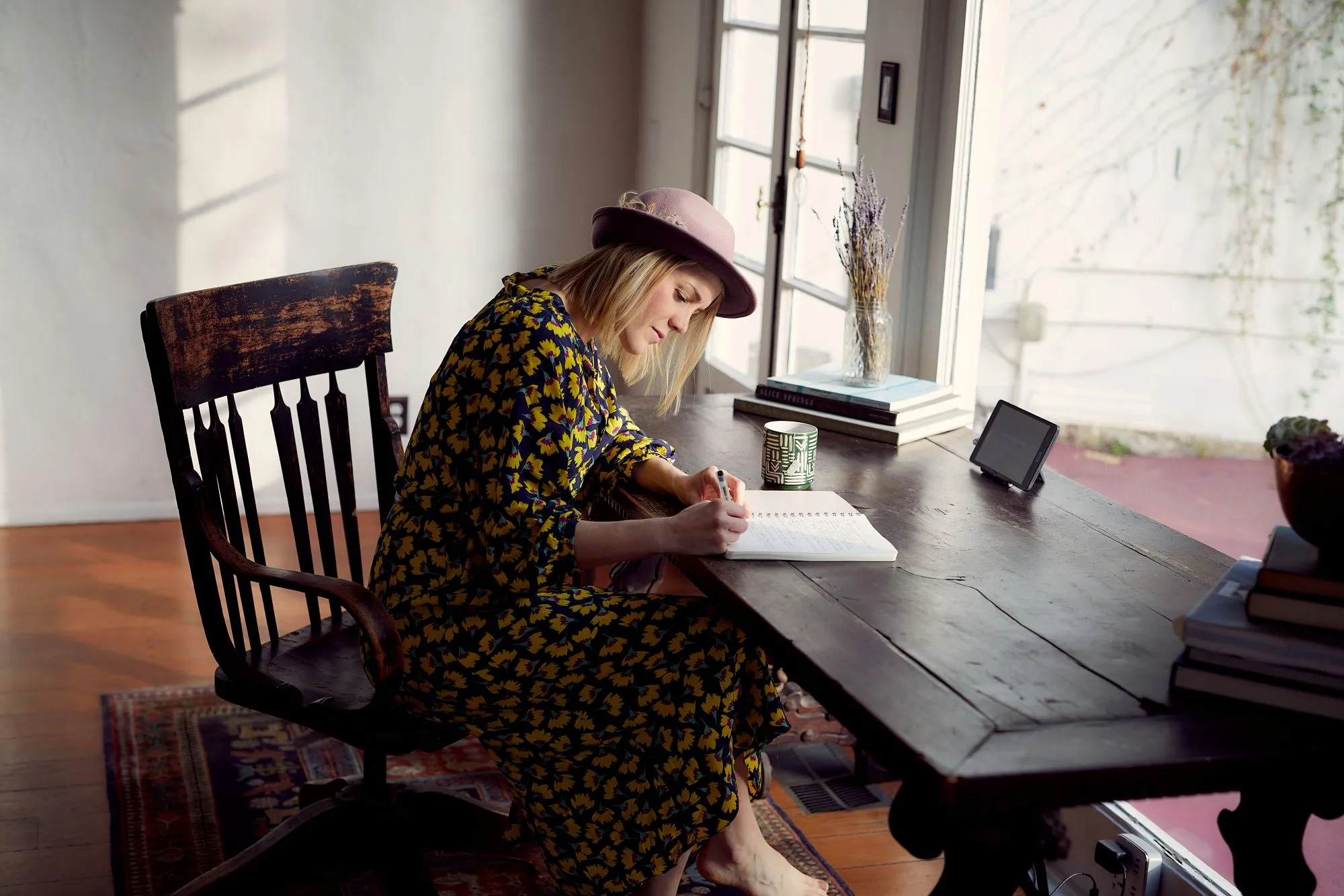 Améliorer son style d'écriture : une femme assise à une table qui écrit sa biographie dans un carnet