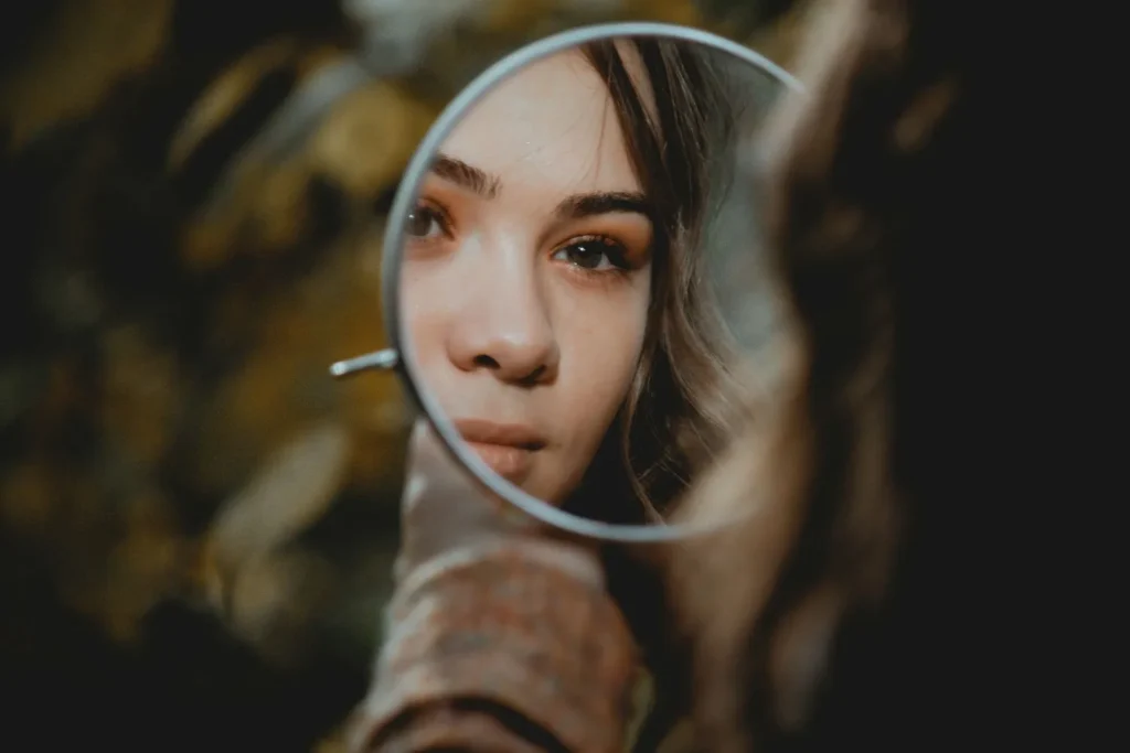 "Ma vie n'intéresse personne" semble penser une femme qui se regarde dans un miroir. Photo : Elisa Photography sur Unsplash